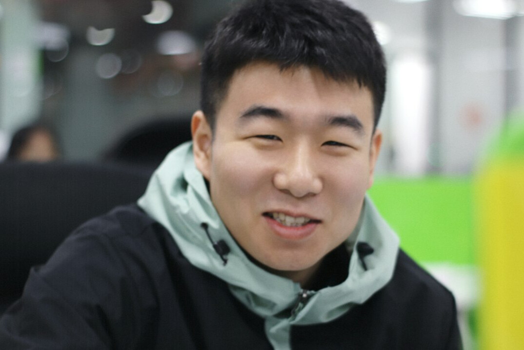 Portrait of a young Malay man smiling in a modern office